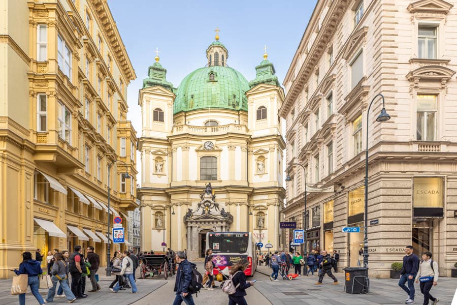 維也納聖伯多祿教堂(Peterskirche)外觀，綠色圓頂矗立街道盡頭，周圍被典雅歐洲街屋包圍。