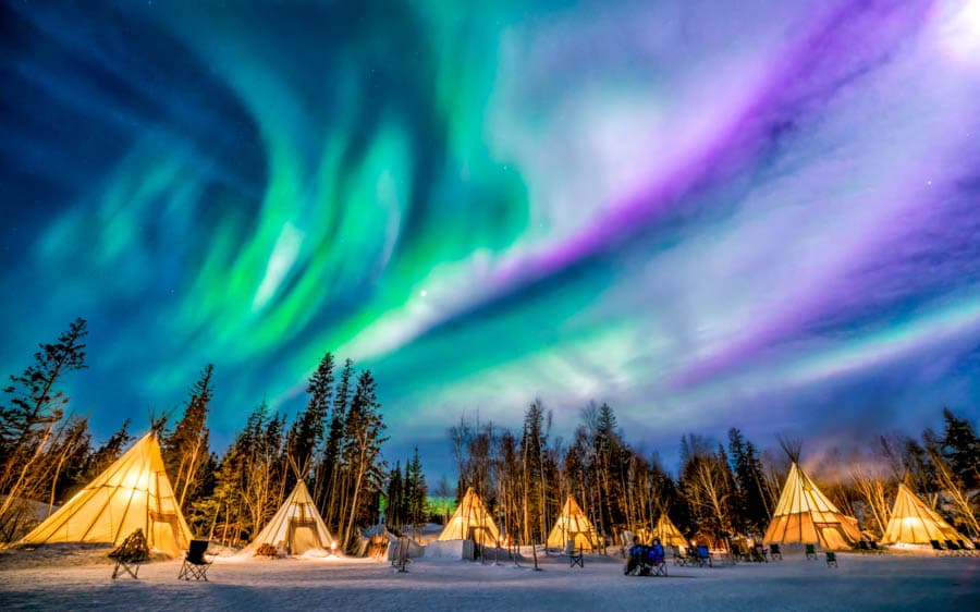 極光下的傳統圓錐帳篷(Teepees)