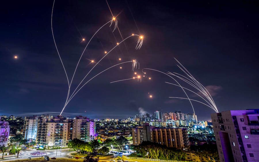 以色列城市夜空中，鐵穹防空系統攔截來襲火箭彈，留下多道飛行光軌