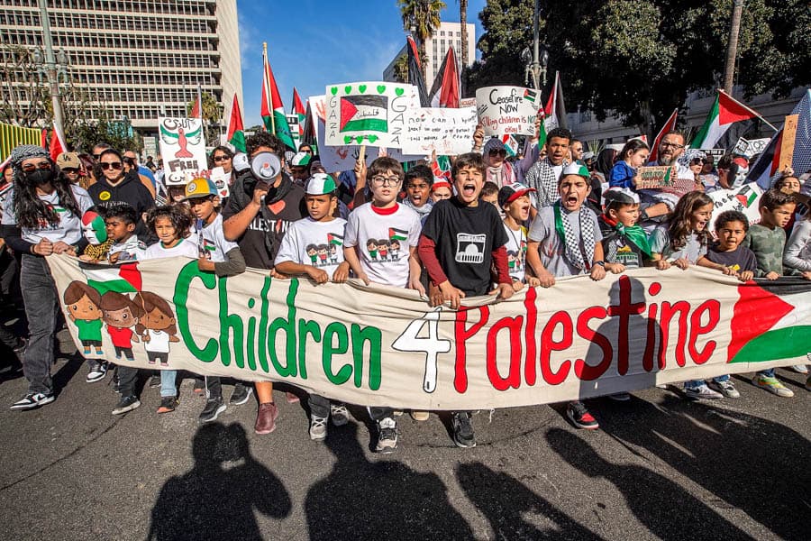 美國年輕人在街頭參與支持巴勒斯坦示威活動，高舉旗幟與標語要求停火