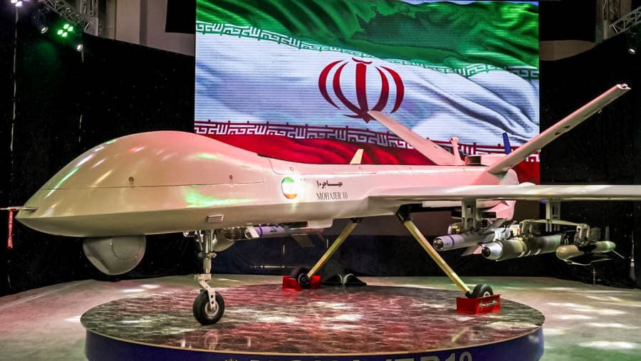 伊朗展場內展示軍用無人機，背景為伊朗國旗，象徵遠程攻擊與軍事威懾能力
