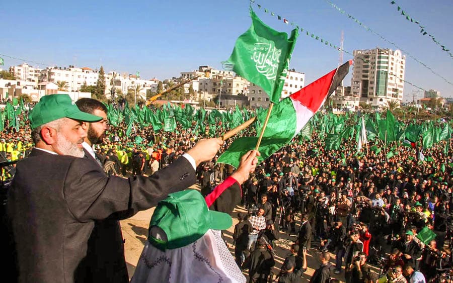 加薩大型群眾集會現場，台上人士揮舞巴勒斯坦旗與綠色旗幟，廣場聚集大量支持者。