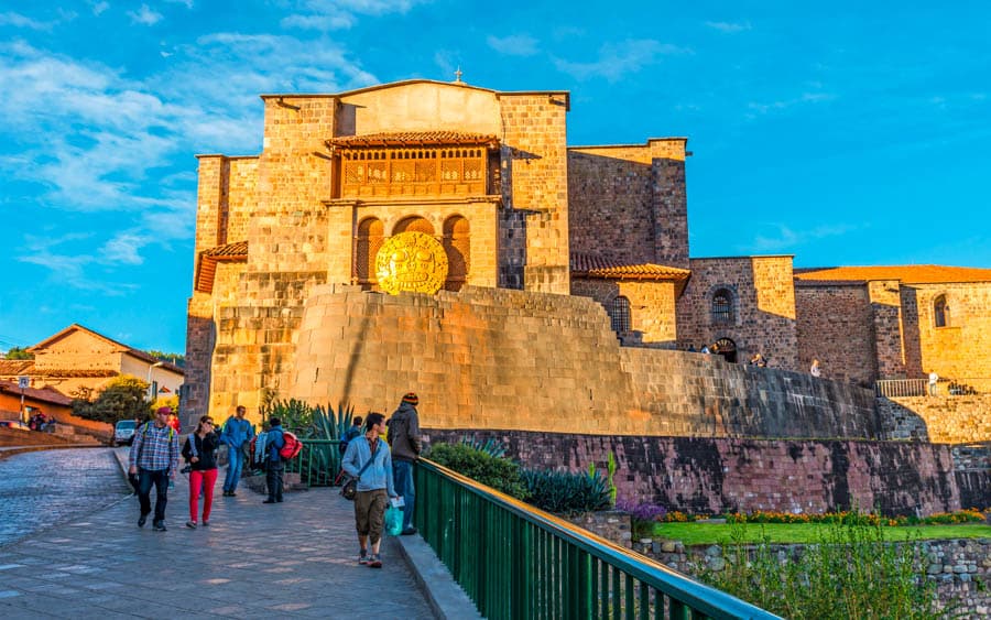 秘魯庫斯科的太陽神殿(Qorikancha),圖中顯示的巨石牆基座是原始的印加建築,上方則由西班牙殖民者建造了聖多明哥修道院 (Convento de Santo Domingo)。牆面上懸掛的金色圓盤是為太陽祭 (Inti Raymi) 慶典所放置的裝飾。