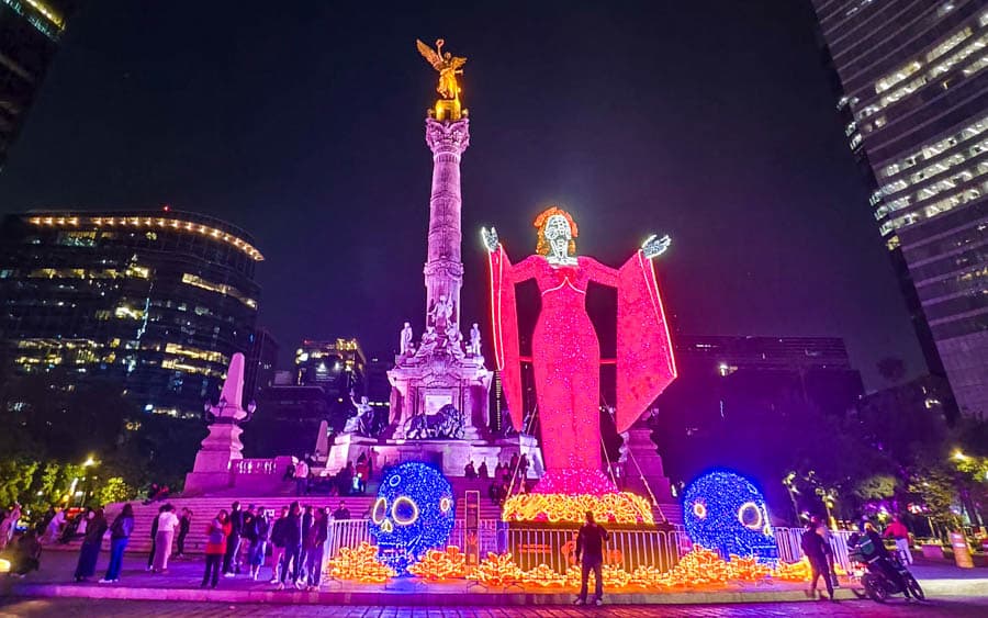 夜間獨立柱圓環絢麗的亡靈節巨型卡翠娜和獨立天使相映成趣