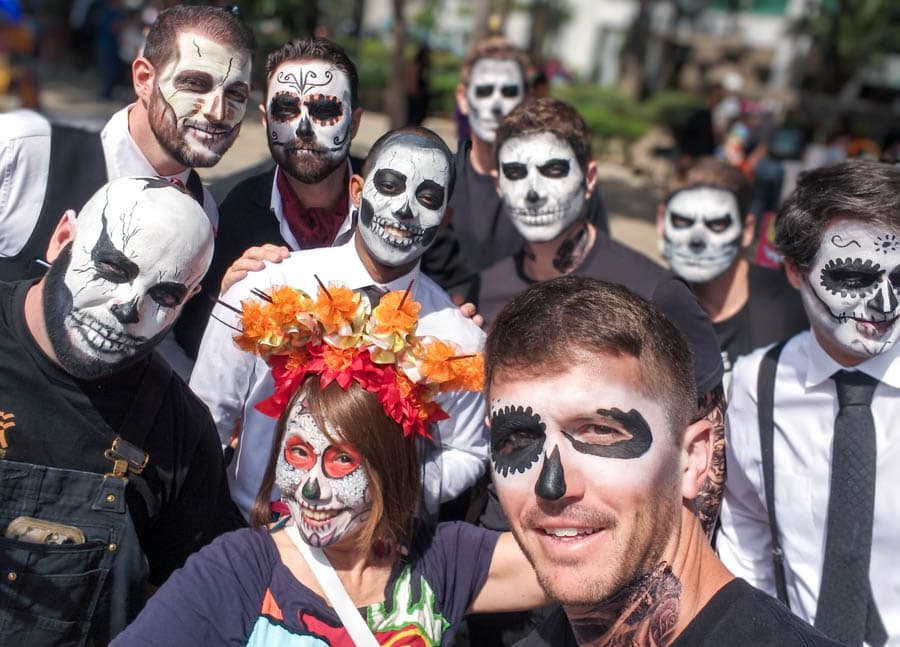 男性以白色顏料為底，用黑色勾勒眼窩、鼻腔和牙齒的亡靈節骷髏