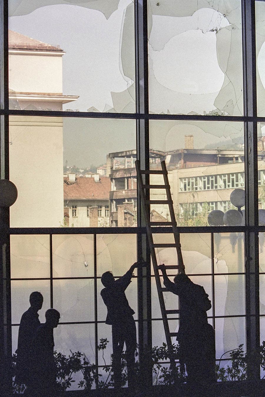 薩拉耶佛假日酒店員工忙著將被炸破的玻璃用塑膠布罩住